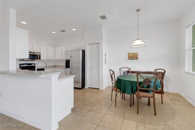 14573 Abaco Lakes Dr Unit 102, Fort Myers, FL 33908 - kitchen with stainless steel appliances, light countertops, white cabinetry, a peninsula, and recessed lighting