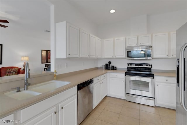 14573 Abaco Lakes Dr Unit 102, Fort Myers, FL 33908 - kitchen with stainless steel appliances, a sink, light tile patterned floors, white cabinetry, and recessed lighting