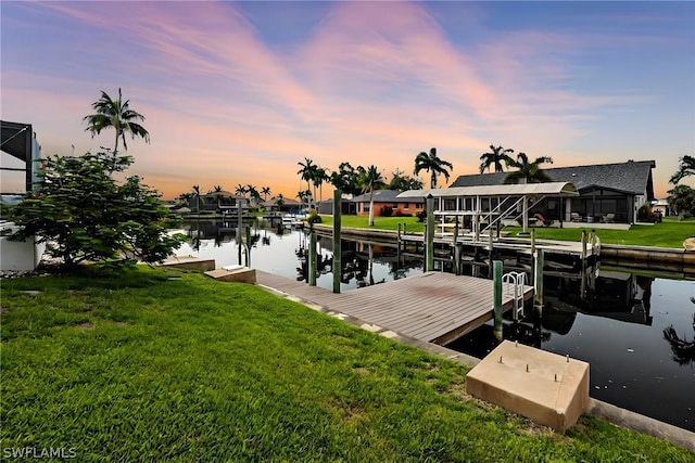 dock area featuring a lawn and a water view