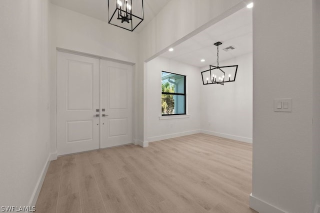 entrance foyer with a notable chandelier and light hardwood / wood-style flooring