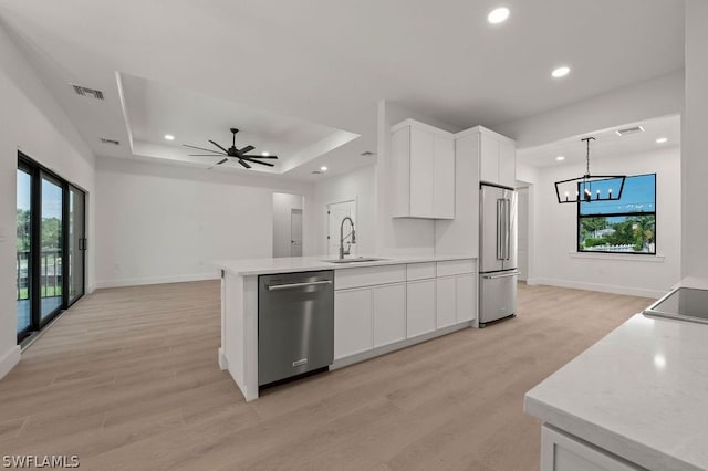 kitchen with white cabinetry, sink, light hardwood / wood-style floors, pendant lighting, and appliances with stainless steel finishes