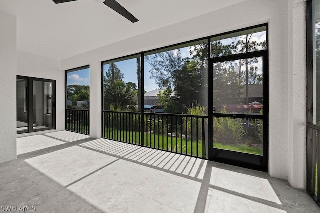 unfurnished sunroom featuring ceiling fan