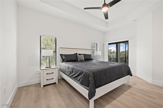 27071 Holly Ln, Bonita Springs, FL 34135 - bedroom with light wood-type flooring, access to outside, multiple windows, and a tray ceiling