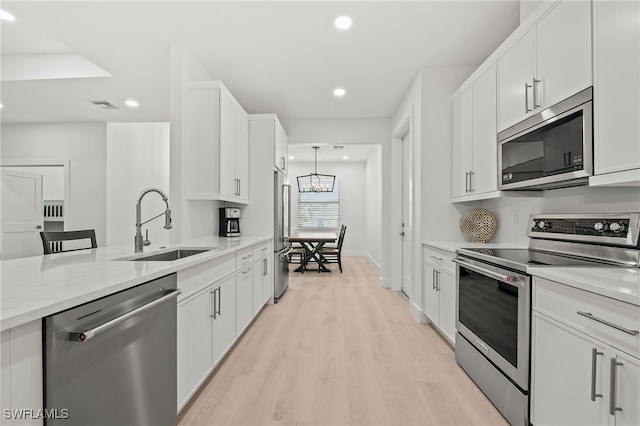 27071 Holly Ln, Bonita Springs, FL 34135 - kitchen with stainless steel appliances, white cabinets, and a sink