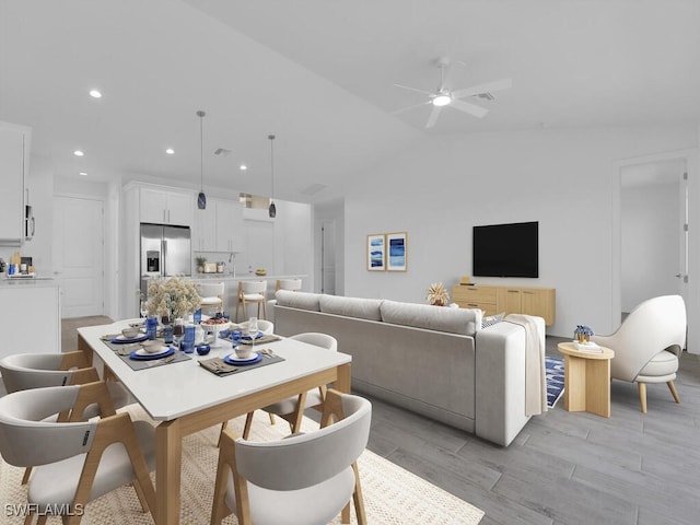 dining room featuring light hardwood / wood-style floors, ceiling fan, and lofted ceiling