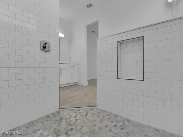 bathroom with vanity and a tile shower