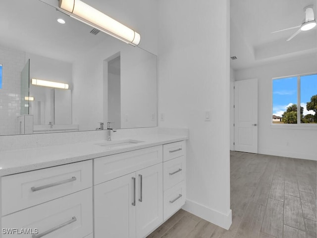 bathroom with ceiling fan, hardwood / wood-style flooring, decorative backsplash, and vanity