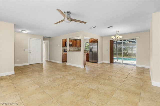 unfurnished living room with ceiling fan with notable chandelier and light tile floors