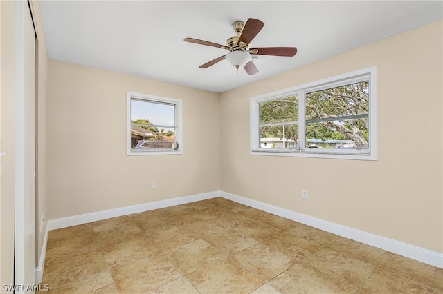 tiled spare room featuring ceiling fan