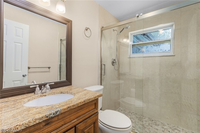 bathroom featuring walk in shower, vanity, and toilet