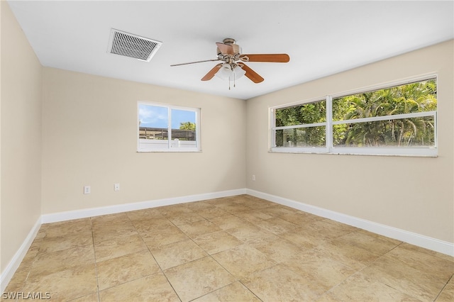 tiled spare room with ceiling fan