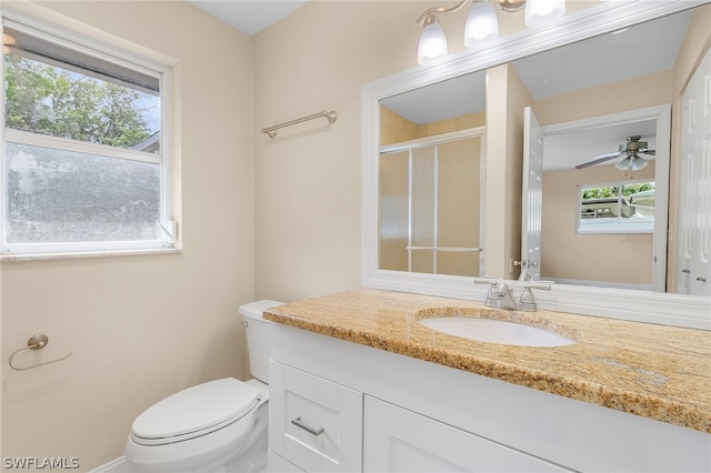 bathroom with vanity with extensive cabinet space, plenty of natural light, ceiling fan, and toilet