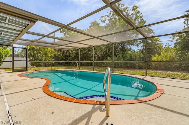 view of pool with glass enclosure and a patio