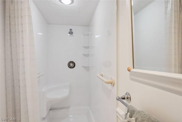 bathroom with a textured ceiling and walk in shower