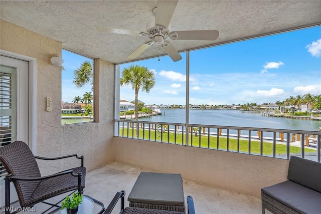 balcony with a water view and ceiling fan