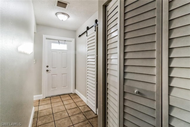 251 Palm Dr Unit 251-2, Naples, FL 34112 - entryway featuring baseboards, light tile patterned flooring, a textured ceiling, and a barn door