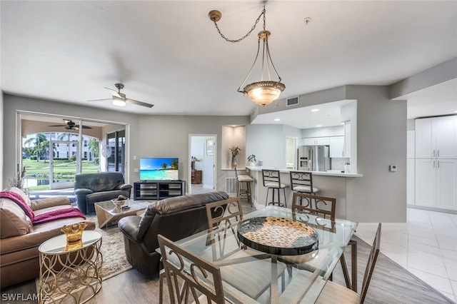 tiled dining space with ceiling fan