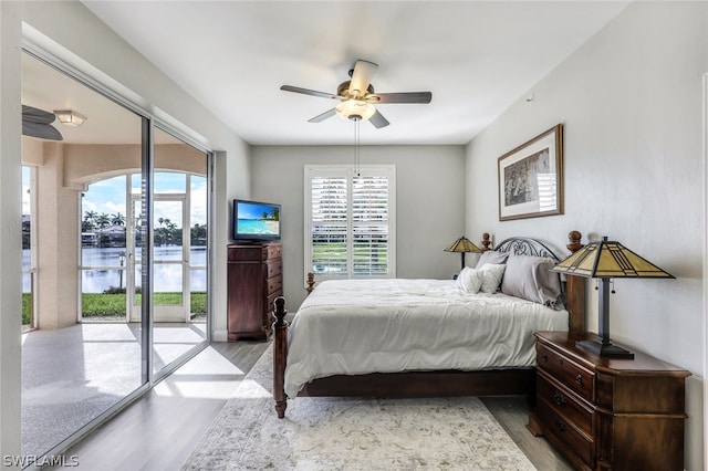 bedroom featuring access to exterior, light hardwood / wood-style flooring, and ceiling fan