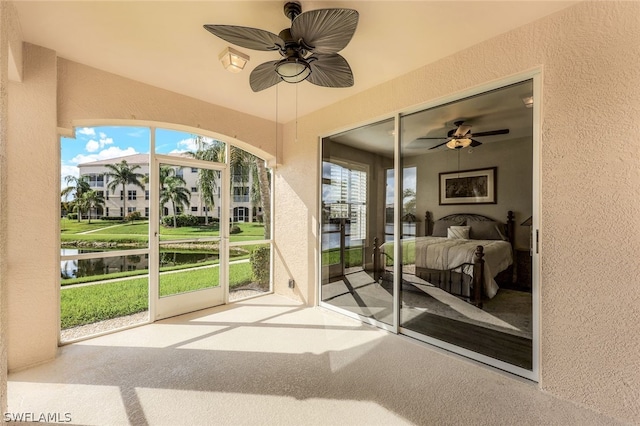 sunroom / solarium with a water view and ceiling fan