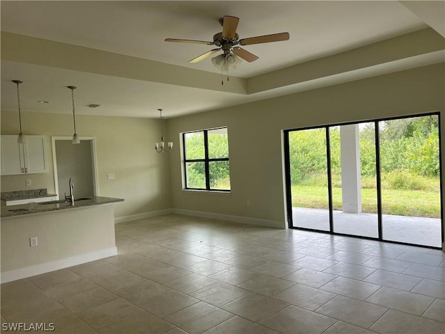 unfurnished room featuring ceiling fan with notable chandelier and sink