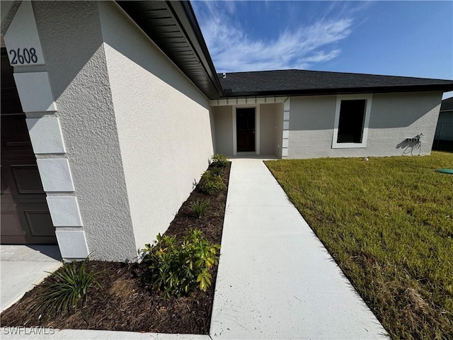 entrance to property featuring a yard