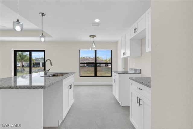 kitchen featuring a sink, light stone countertops, healthy amount of natural light, white cabinetry, and recessed lighting