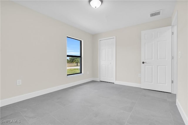 unfurnished bedroom featuring baseboards, a closet, and tile patterned flooring