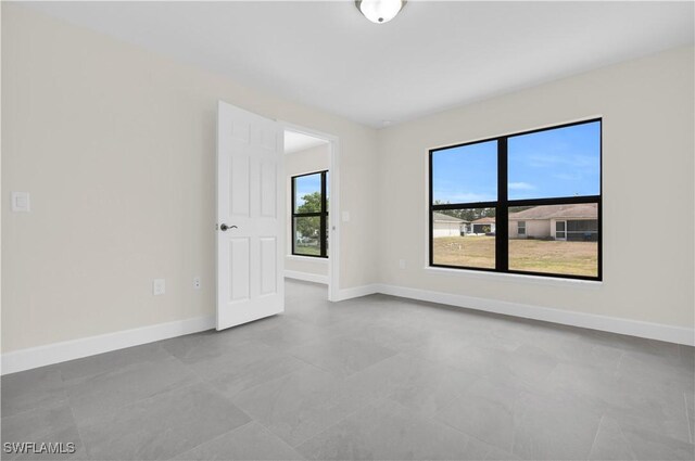 spare room with baseboards