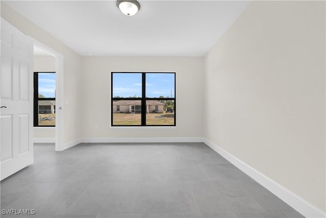 unfurnished room featuring healthy amount of natural light, baseboards, and tile patterned floors