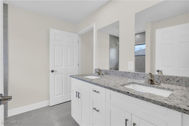 bathroom with tile patterned floors, baseboards, and double vanity