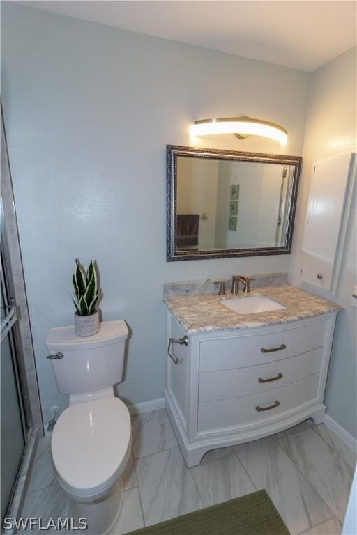 bathroom with vanity, toilet, and a shower with shower door