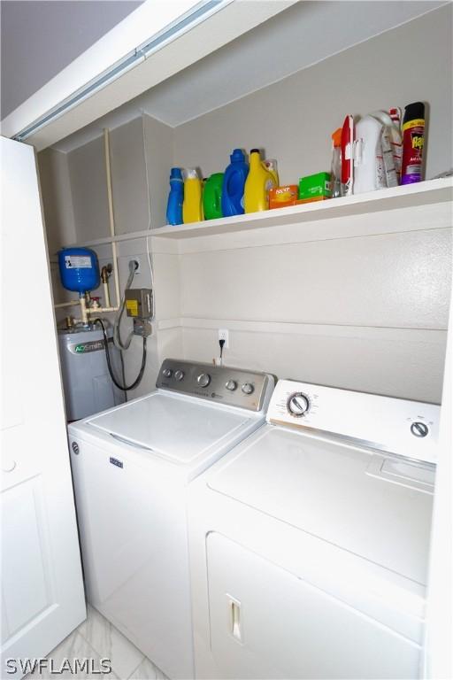 laundry room with electric water heater and independent washer and dryer