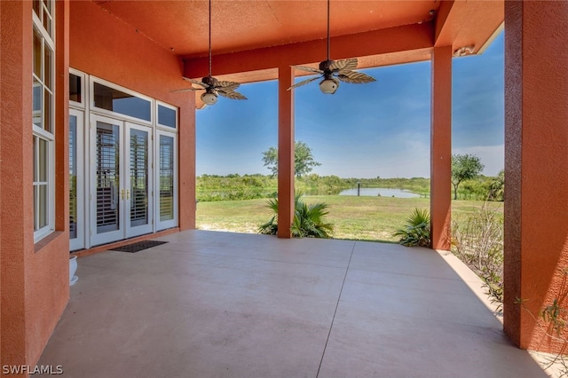 view of patio / terrace with ceiling fan, a water view, and french doors