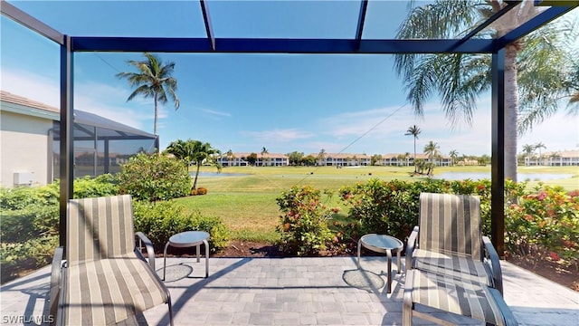 view of patio with a water view and glass enclosure