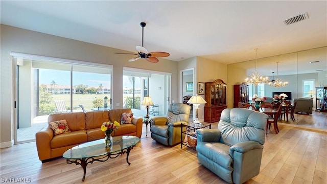 living room featuring light hardwood / wood-style floors and ceiling fan with notable chandelier