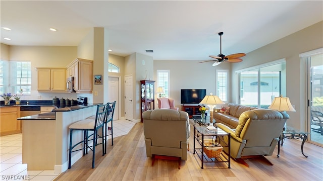 living room with light hardwood / wood-style flooring, a wealth of natural light, and ceiling fan