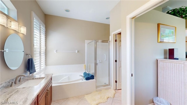 bathroom featuring plus walk in shower, vanity, and tile patterned flooring