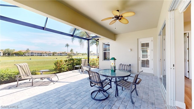 view of patio / terrace featuring ceiling fan and a lanai