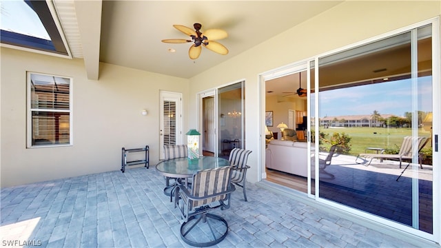 sunroom / solarium with beamed ceiling and ceiling fan