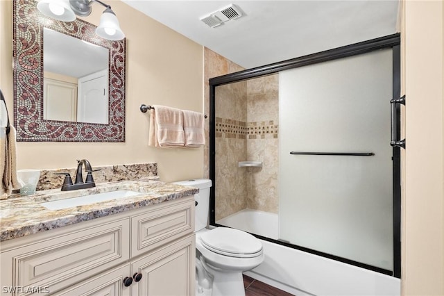 full bathroom with shower / bath combination with glass door, vanity, and toilet