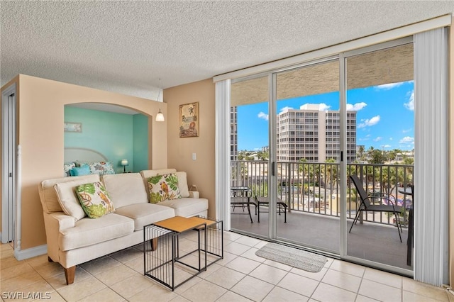 7300 Estero Blvd Unit 301, Fort Myers Beach, FL 33931 - living room with expansive windows, plenty of natural light, a textured ceiling, arched walkways, and tile patterned floors