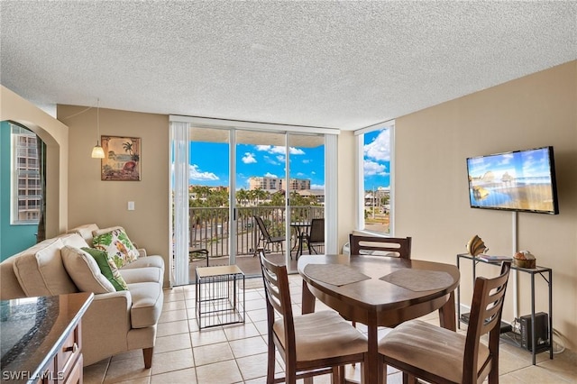 7300 Estero Blvd Unit 301, Fort Myers Beach, FL 33931 - dining area featuring light tile patterned floors, expansive windows, a textured ceiling, and arched walkways