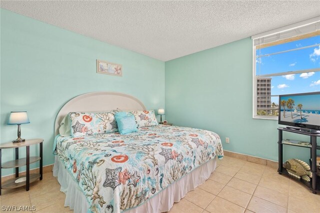 bedroom featuring light tile patterned floors and a textured ceiling