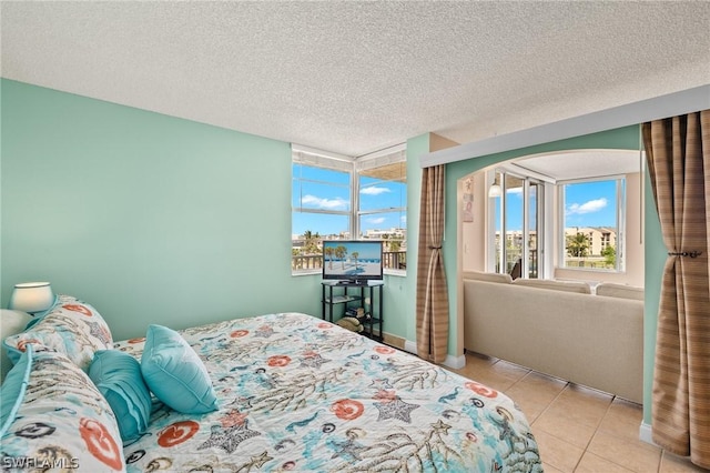 bedroom featuring light tile patterned floors and a textured ceiling