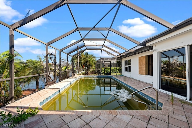 view of swimming pool featuring a patio, a water view, and a lanai