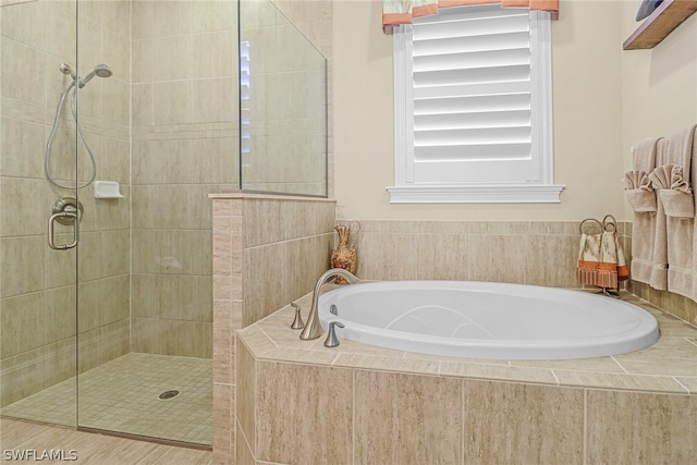 bathroom featuring shower with separate bathtub