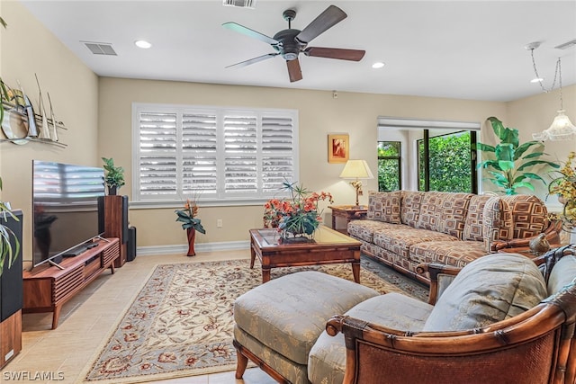 tiled living room featuring ceiling fan and a healthy amount of sunlight