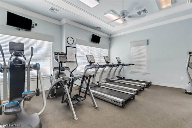 workout area with ceiling fan, crown molding, and a raised ceiling