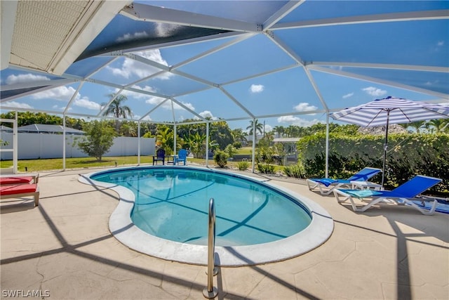 view of pool featuring glass enclosure and a patio