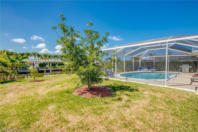 view of yard with glass enclosure and a water view